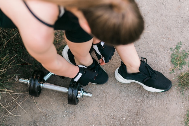 Chiuda in su delle mani e delle gambe della donna che si levano in piedi sul terreno.