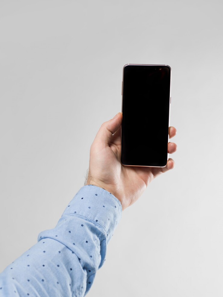 Foto gratuito chiuda in su dello smartphone della holding della mano dell'uomo verticalmente su bianco