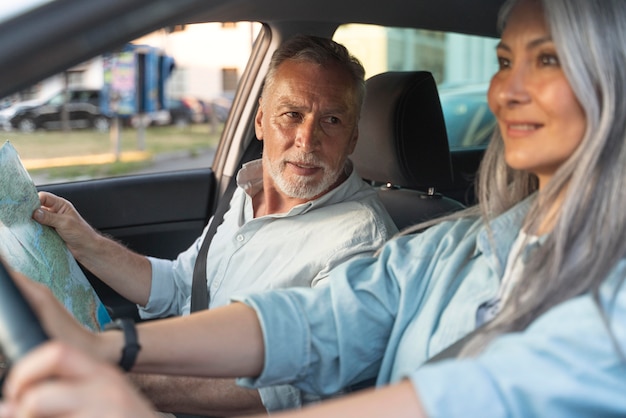 Chiuda in su persone anziane sorridenti in auto