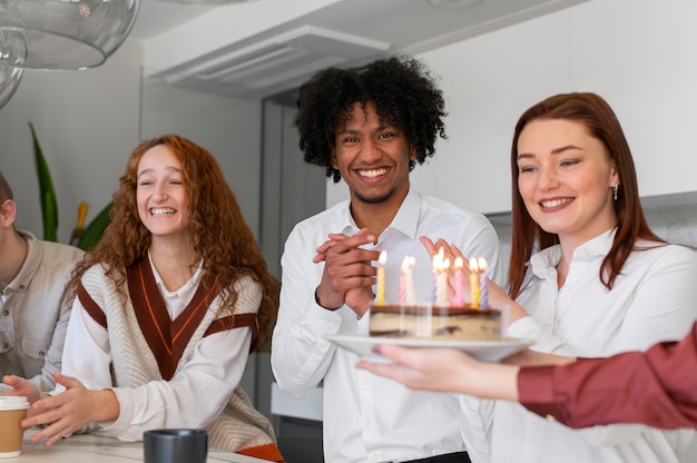 Chiuda in su persone sorridenti con la torta