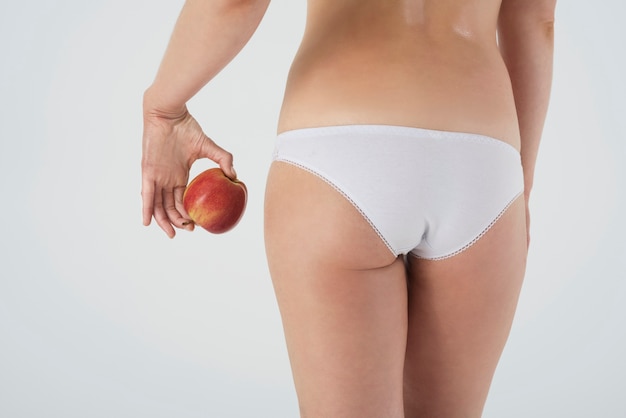 Chiuda in sulle gambe della donna in biancheria intima di base isolata