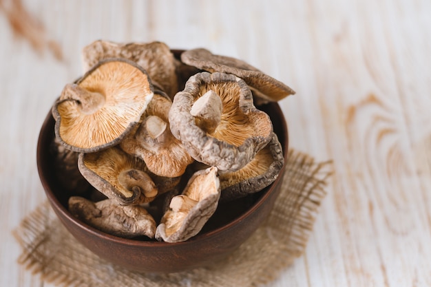 Chiuda su dei funghi di shiitake secchi su fondo di legno