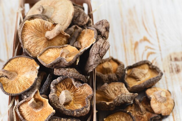 Chiuda su dei funghi di shiitake secchi su fondo di legno