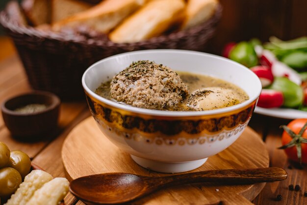 Chiuda su della minestra di polpetta azera di kofta guarnita con le foglie di menta secche