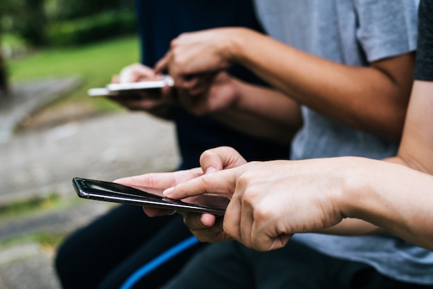 Chiuda su delle mani degli amici giocano insieme con lo smartphone.