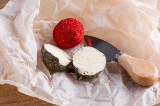 Chiuda su formaggio tagliato a metà sulla tavola