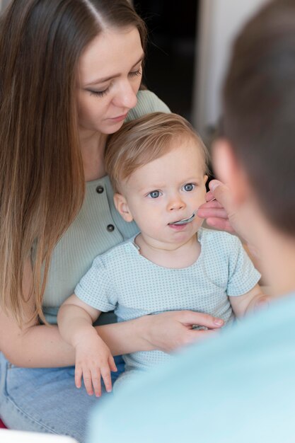 Chiuda sui genitori che alimentano il bambino