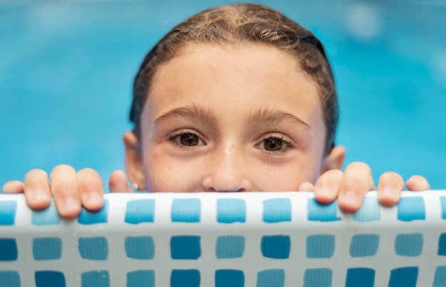 Chiuda sul bambino bagnato in piscina