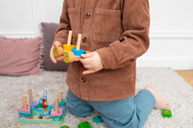 Chiuda sul bambino che gioca con il giocattolo educativo