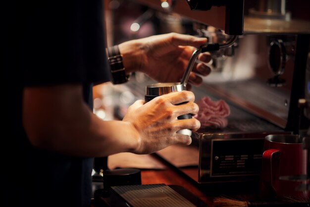 Chiuda sul barista che produce il cappuccino, barista che prepara la bevanda del caffè