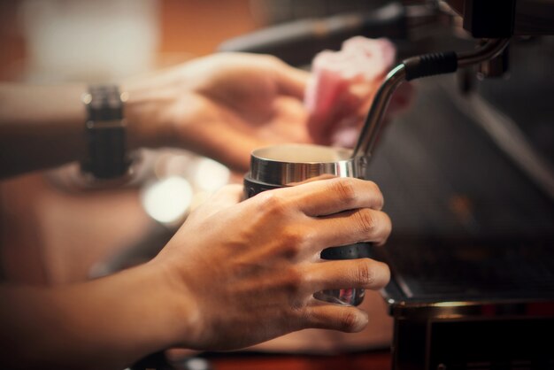 Chiuda sul barista che produce il cappuccino, barista che prepara la bevanda del caffè