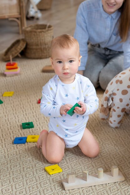 Chiuda sul giocattolo sveglio della holding del bambino