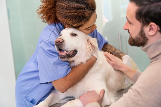 Chiuda sul medico che abbraccia il cane sorridente