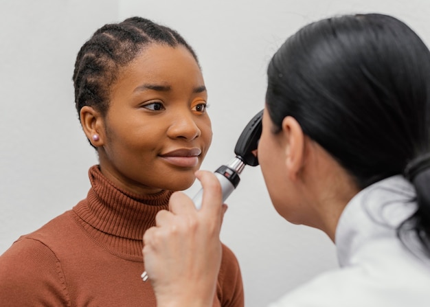 Chiuda sul medico che controlla l'occhio del paziente