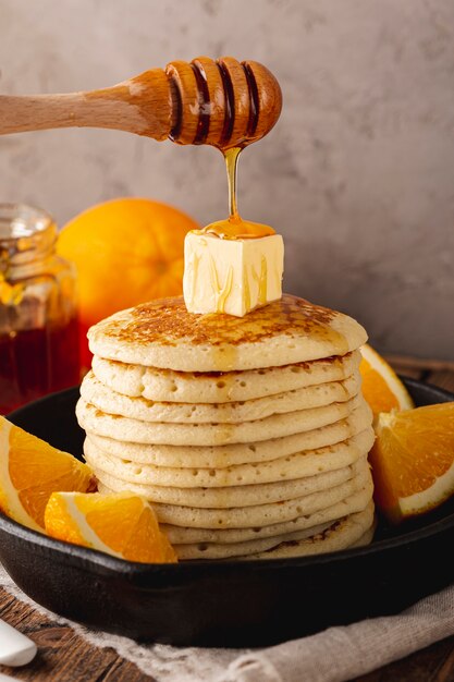 Chiuda sul miele che gocciola dal merlo acquaiolo sopra i pancake