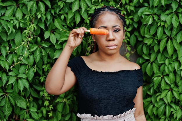 Chiuda sul ritratto della donna afroamericana alla moda con il gelato