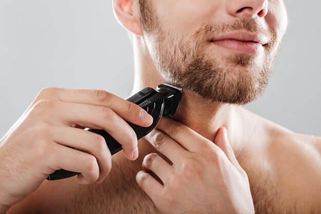 Chiuda sul ritratto di un uomo sorridente che rade la sua barba