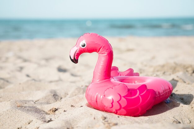 Chiuda sull&#39;anello gonfiabile di nuotata del fenicottero sulla spiaggia