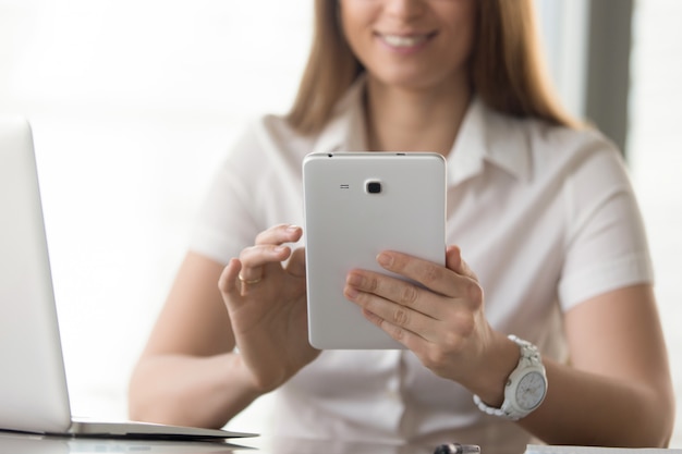 Chiuda sull&#39;immagine della compressa digitale in mani della donna