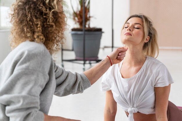 Chiuda sull'insegnante che aiuta la donna con la posa