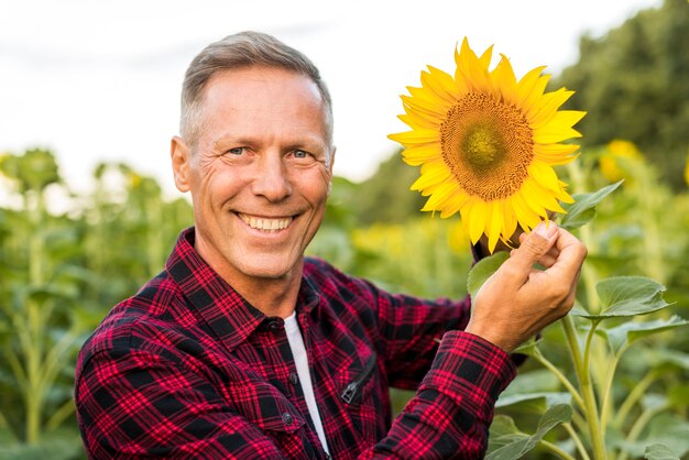 Chiuda sull'uomo sorridente che esamina la macchina fotografica
