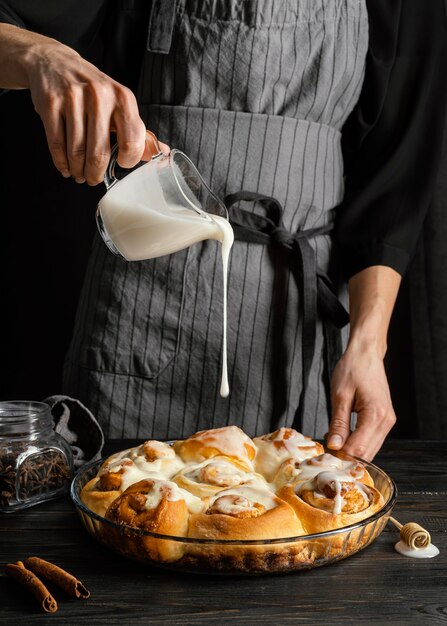 Chiuda sulla crema di versamento della mano sul dessert