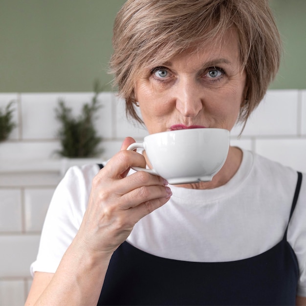 Chiuda sulla donna che beve dalla tazza