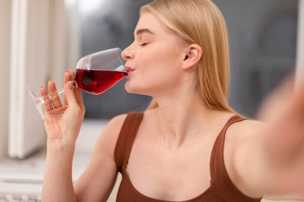 Chiuda sulla donna che beve vino rosso