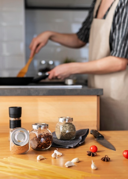 Chiuda sulla donna che cucina con la padella