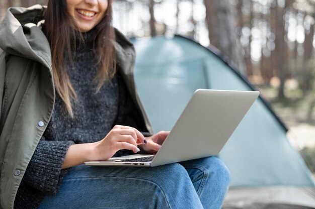 Chiuda sulla donna che lavora al computer portatile