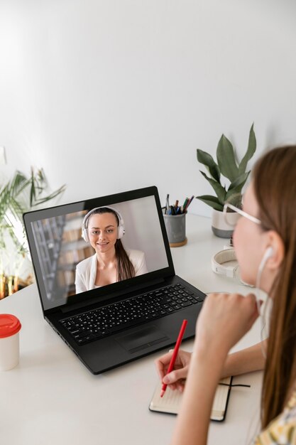 Chiuda sulla donna con il computer portatile