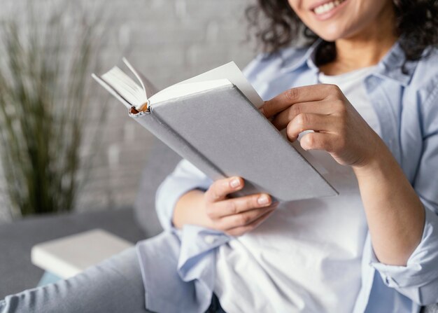 Chiuda sulla donna di smiley con il libro