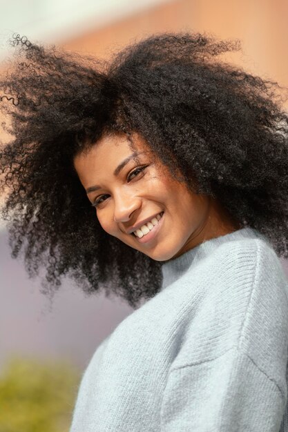 Chiuda sulla donna felice che propone all'aperto