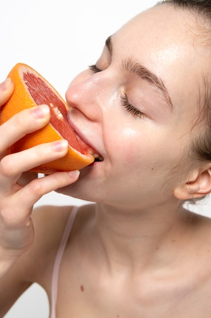 Chiuda sulla donna sorridente che mangia pompelmo