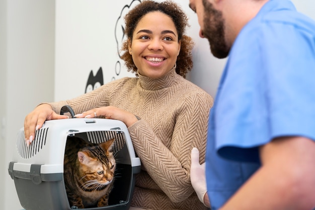 Chiuda sulla donna sorridente con il gatto sveglio
