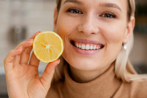 Chiuda sulla fetta di limone della holding della donna