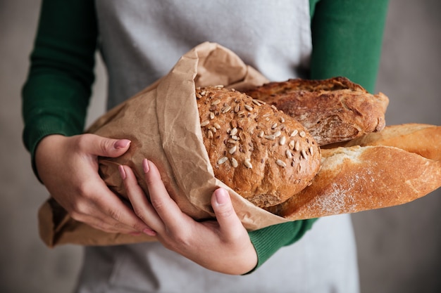 Chiuda sulla foto della borsa femminile della tenuta del panettiere con pane