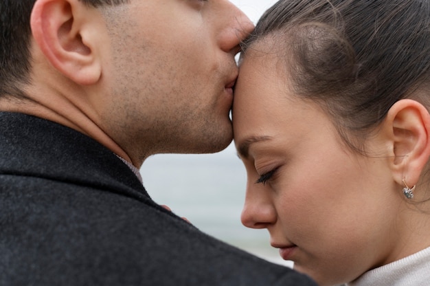 Chiuda sulla fronte della donna che bacia l'uomo