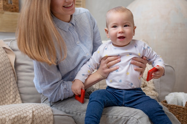 Chiuda sulla madre sorridente che tiene bambino sveglio