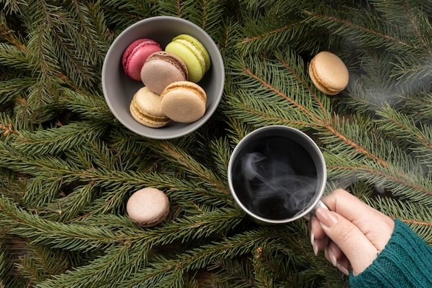 Chiuda sulla mano che tiene tazza di bevanda calda