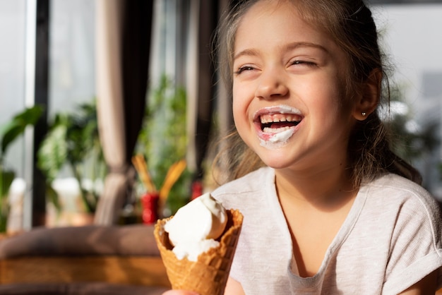 Chiuda sulla ragazza che mangia il gelato