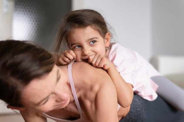 Chiuda sulla ragazza della holding della donna sulla schiena