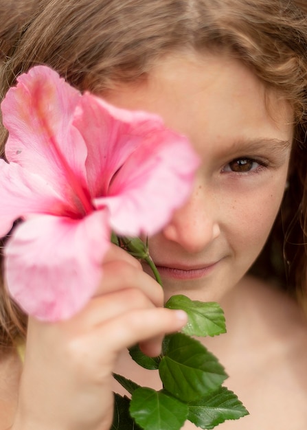 Chiuda sulla ragazza in posa con i fiori