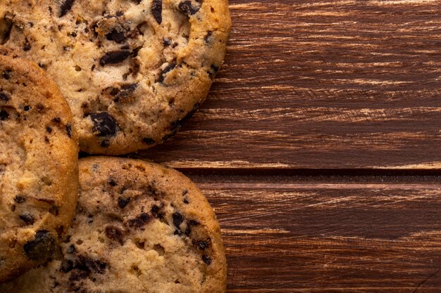 Chiuda sulla vista dei biscotti di farina d'avena con le gocce di cioccolato su di legno