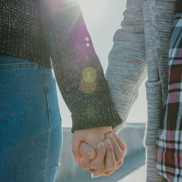 Chiuda sulla vista di tenersi per mano delle coppie