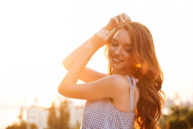 Chiuda sulla vista laterale della donna graziosa sorridente dello zenzero