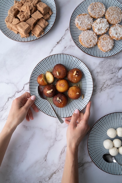 Chiuda sulle mani che tengono il piatto con il dessert