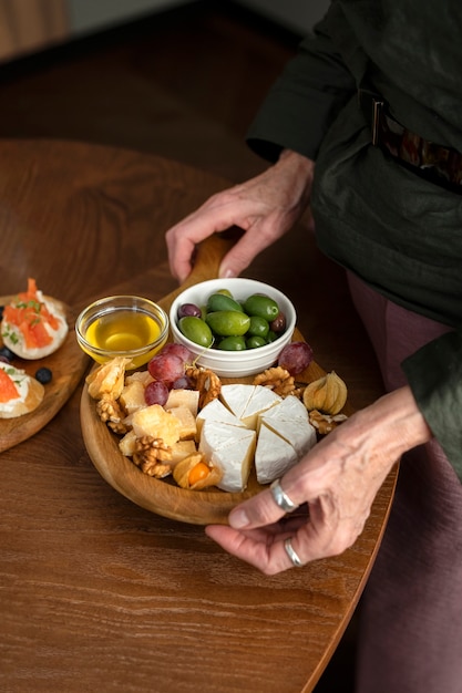 Chiuda sulle mani che tengono la tavola dell'alimento delizioso