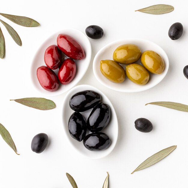 Chiuda sulle olive gialle nere rosse sui piatti