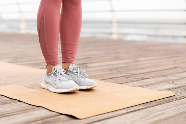 Chiudere le gambe in piedi sul tappetino da yoga